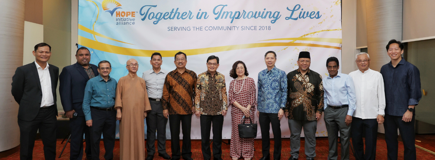 Group of diverse people posed in front of a "Hope Initiative Alliance" banner.